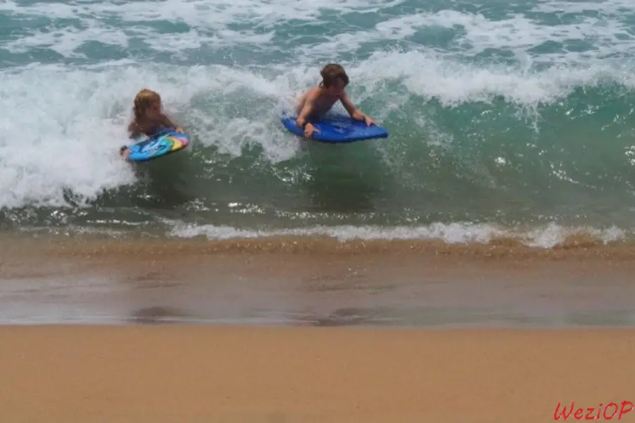 Les enfants jouent dans les vagues sur la plage de San Agustinillo